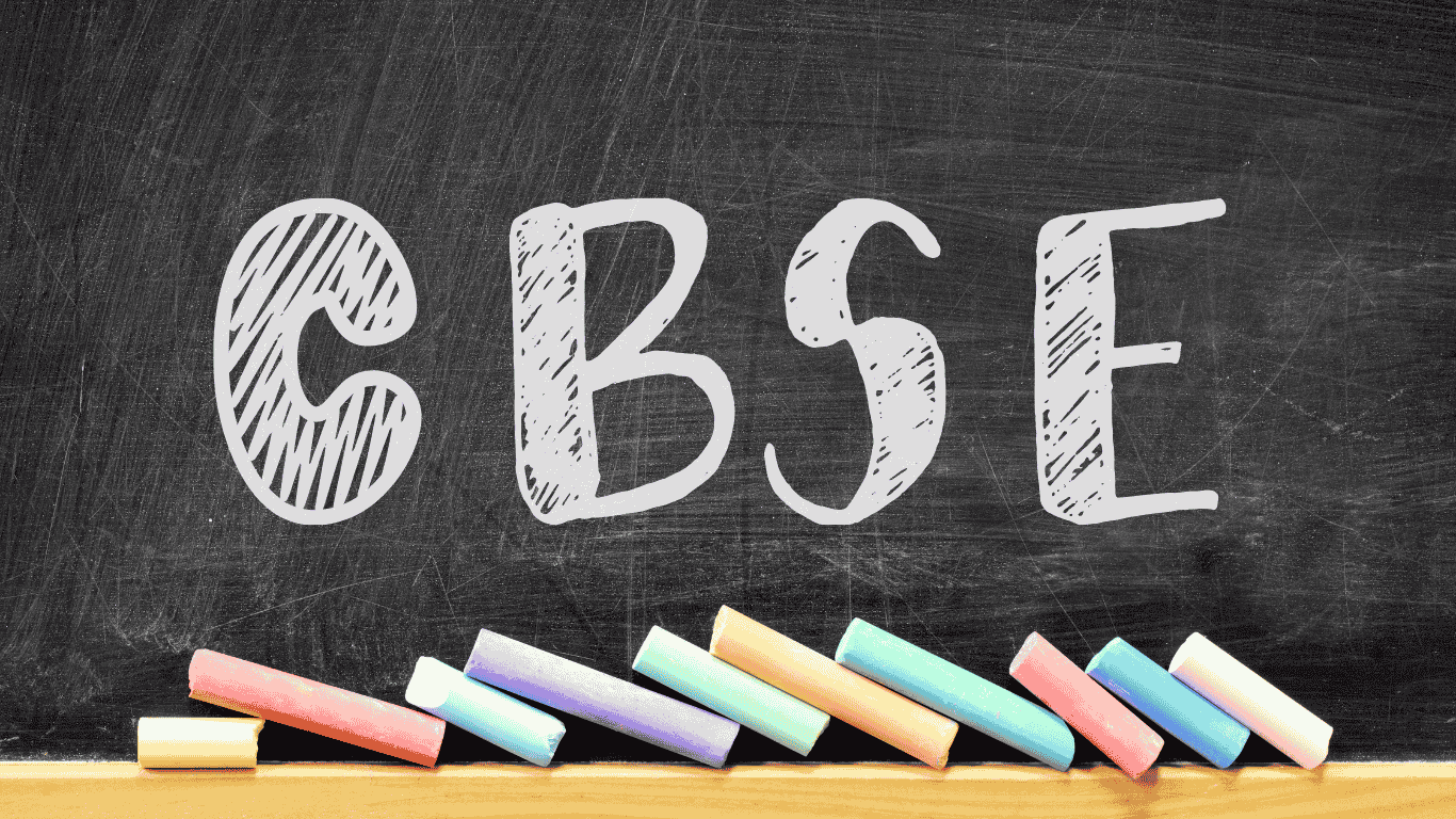A chalkboard with the letters 'CBSE' written in a bold, sketch-style font, accompanied by colorful chalk pieces resting on the bottom ledge.