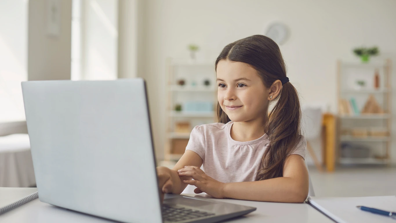A little girl attending online class at home