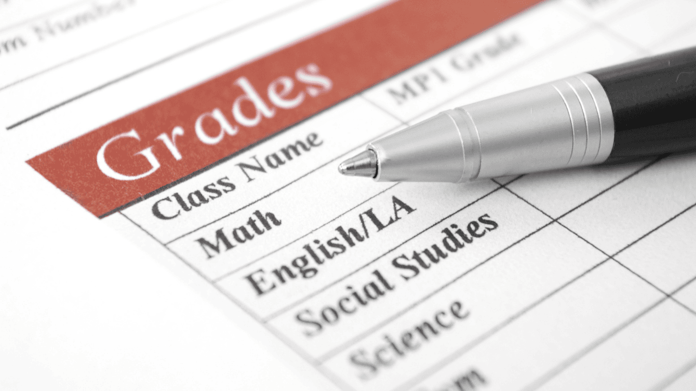 Report card with subjects and grades, and a silver pen on top